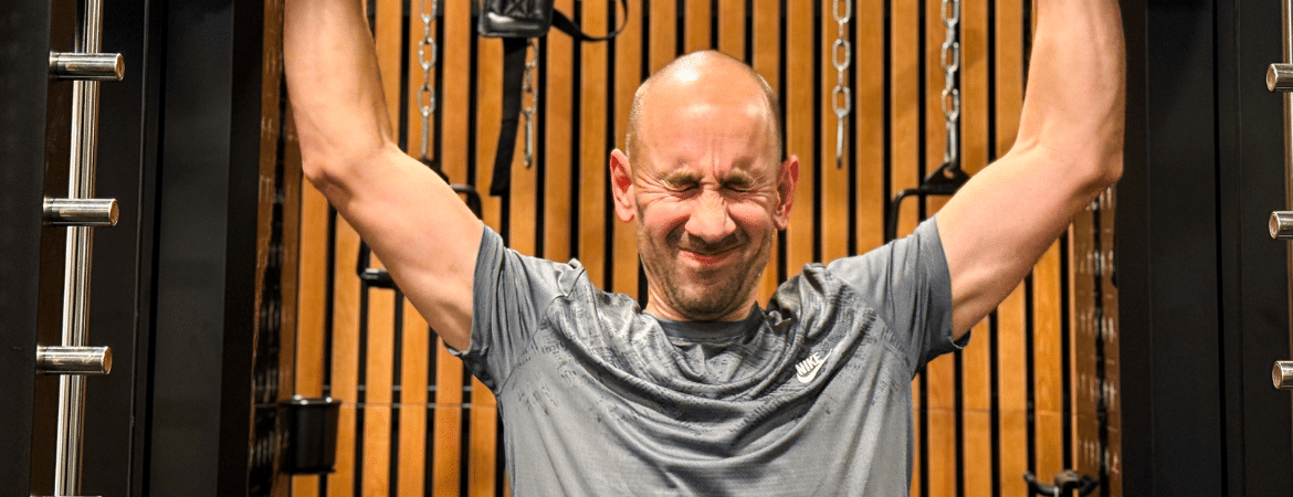 Un homme faisant un effort sur une machine de musculation.